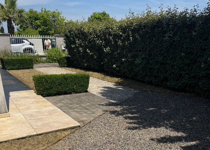 Allée gravillonnée et dallage désherbés après la remise en état du jardin à Genas, haies taillées